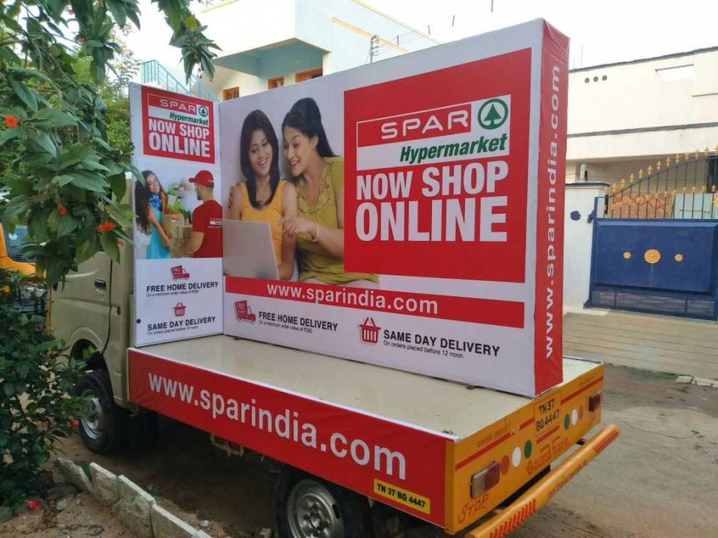 Delivery vehicle branded with SPAR Hypermarket online shopping advertisement parked on a street