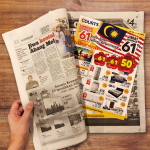 A newspaper insertion advertising campaign featuring promotional retail flyers placed inside a printed newspaper. The image showcases newspaper insert marketing used to distribute brand offers, product catalogs, discounts, and promotional advertisements directly to readers through physical newspaper circulation.