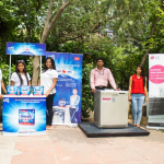 An outdoor product demonstration and experiential marketing setup by Finish and LG showcases a dishwasher activation campaign with brand promoters, display kiosks, and live product interaction in an open public space. The activation combines on-ground engagement, product education, and face-to-face brand interaction to demonstrate dishwasher benefits and hygiene-focused cleaning solutions.