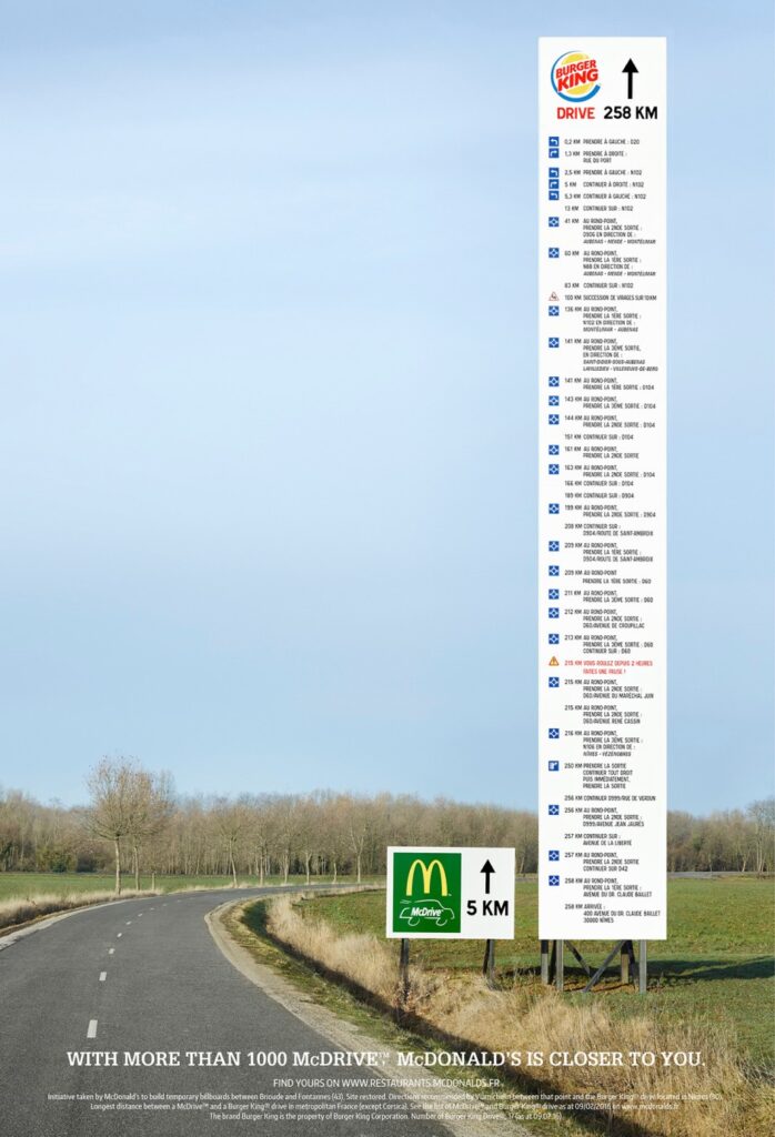 A long billboard that shows the distance comparison between a Burger King's Shop and a McDonald's shop