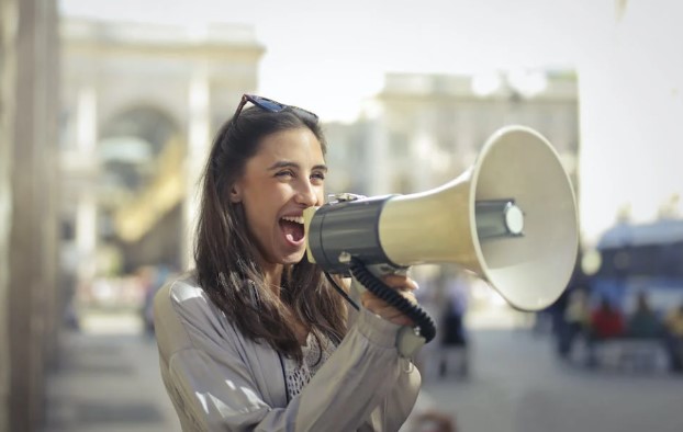 A girl holding speaker and doing offline marketing