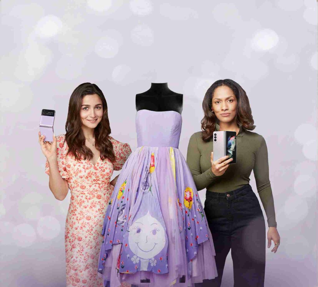 This image shows Alia Bhatt and Masaba Gupta with Samsung Galaxy Z Fold and Flip phones with a lavender dress in between them