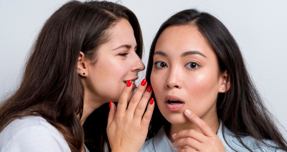 Two young girls talking to each other, possibly discussing word-of-mouth marketing, an offline advertising medium
