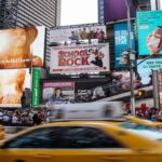 Numerous billboards being displayed on a busy street.