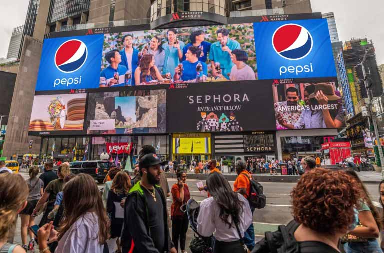A massive crowd of people viewing the billboard.