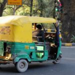 An auto featuring a poster advertisement on its rear side.