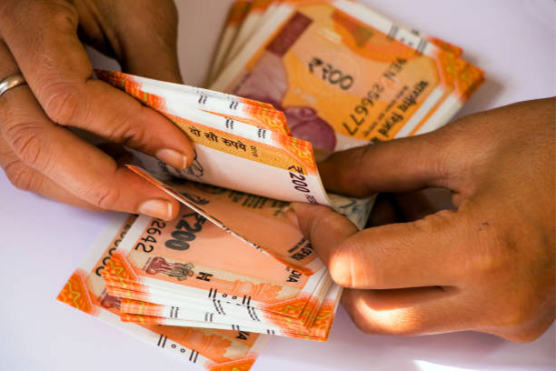A person counting the currency notes.