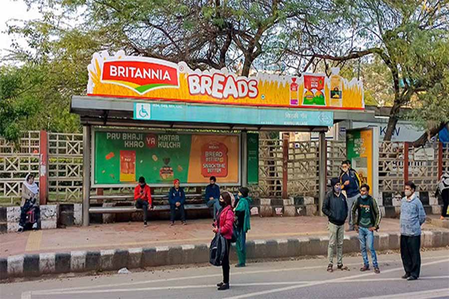 A bus shelter in a high-traffic area featuring Britttania ad.
