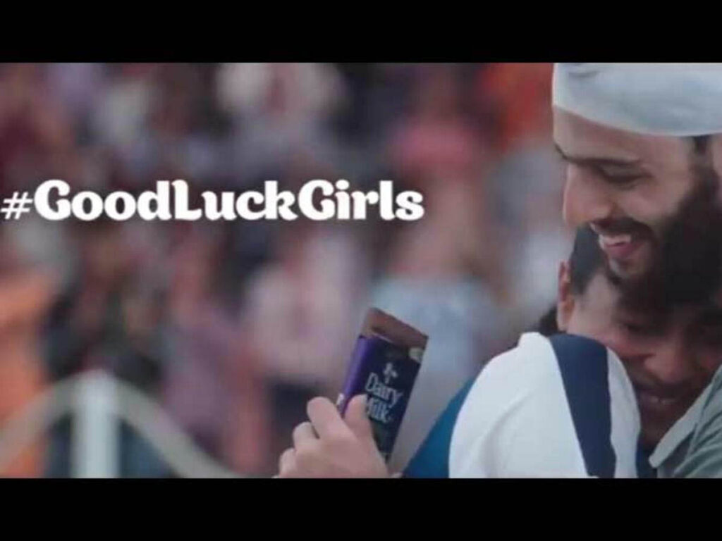A couple celebrating success with a bar of Cadbury chocolate.