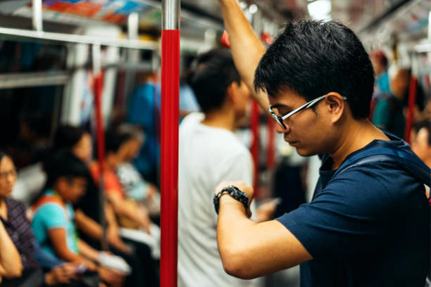 A man looking at his watch while travelling.