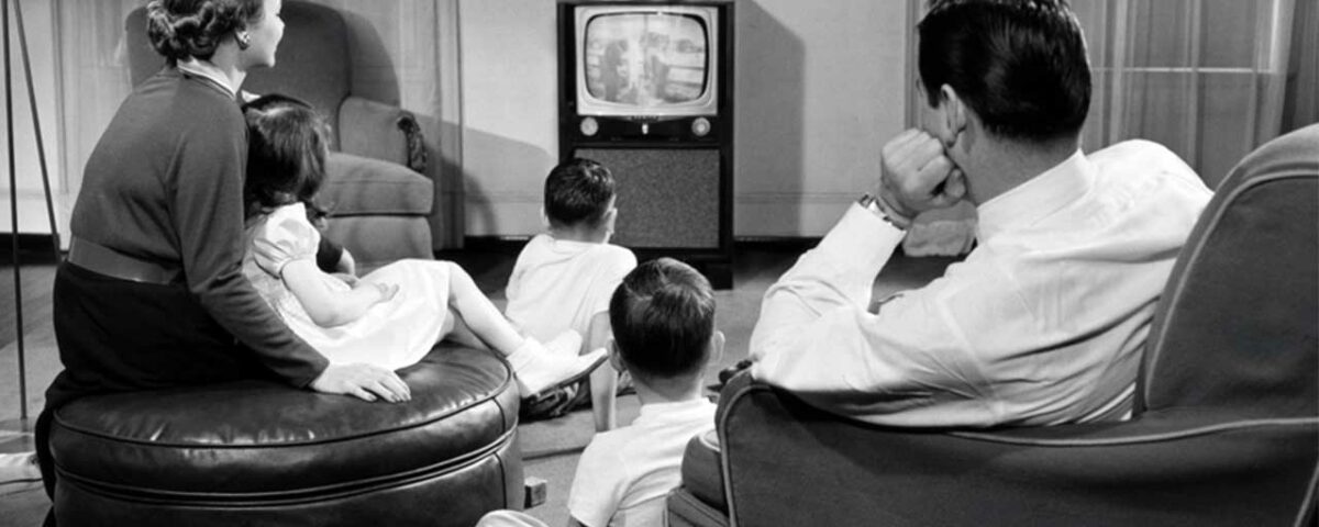 a family sitting together and watching advertisement in TV