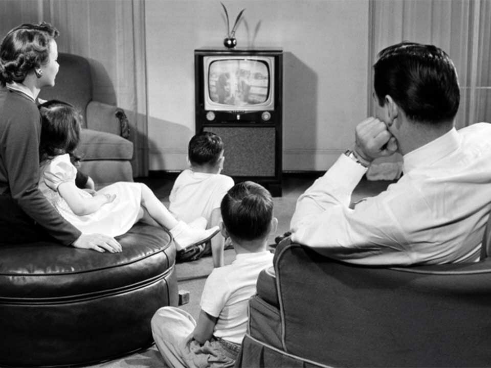 a family sitting together and watching advertisement in TV