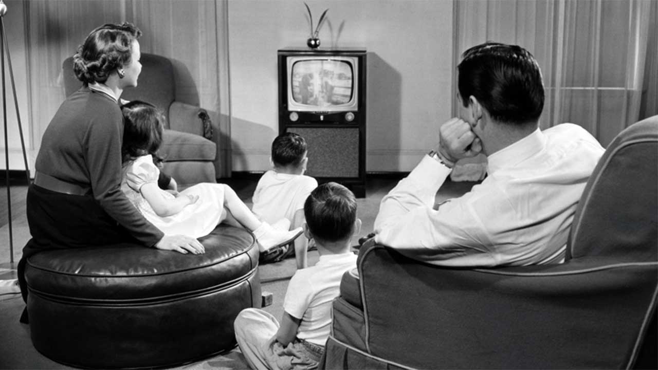 a family sitting together and watching advertisement in TV