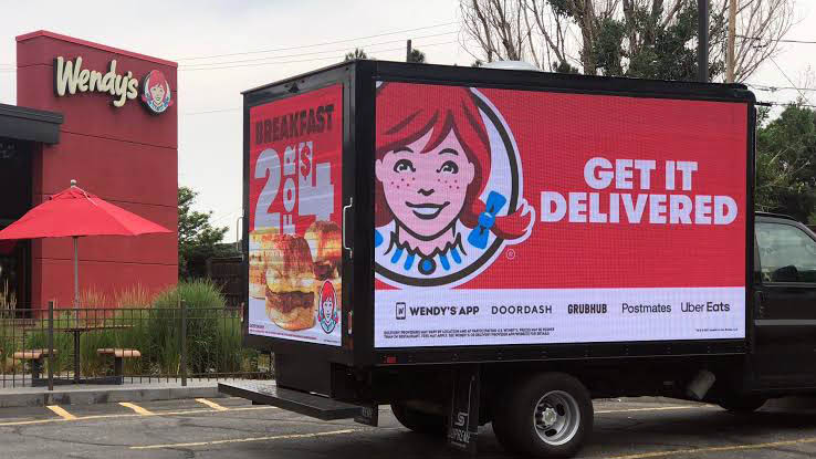 A advertisement of Wendy's on a mobile truck.
