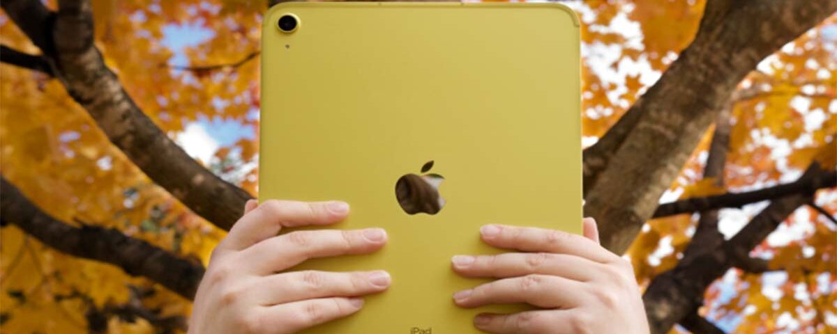 A person holding an Apple iPad air featuring the Apple logo.