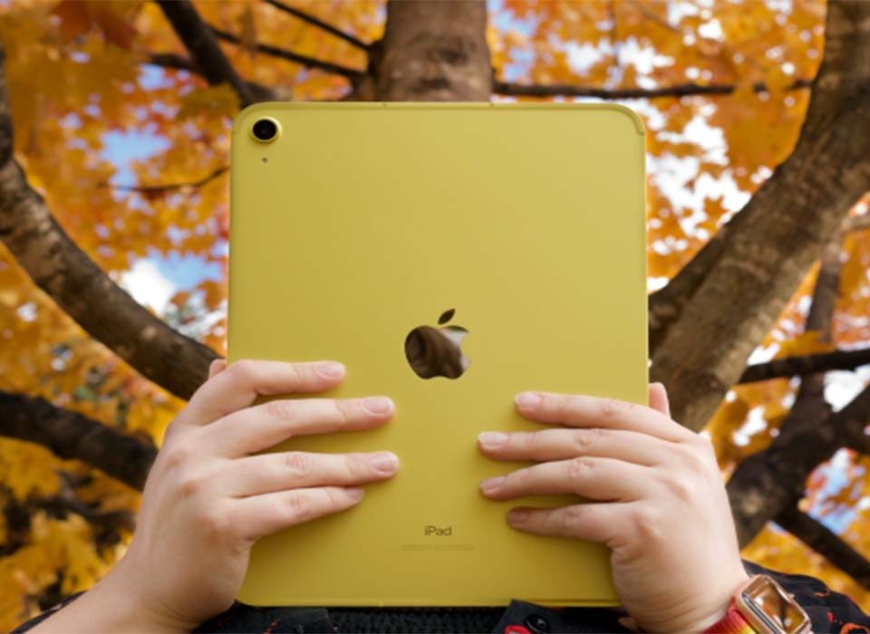 A person holding an Apple iPad air featuring the Apple logo.
