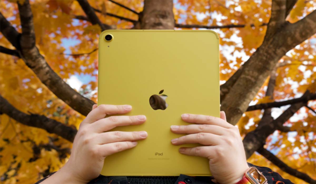 A person holding an Apple iPad air featuring the Apple logo.