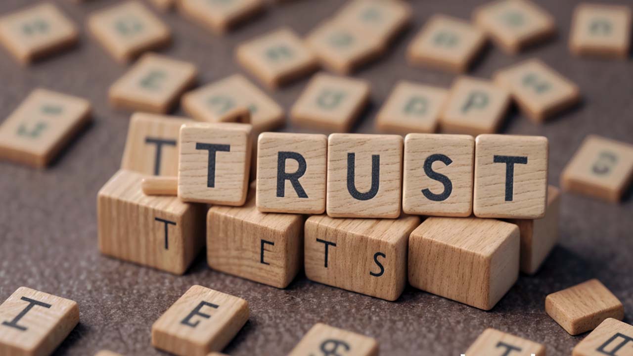 Wooden blocks of letters are used to write the word trust
