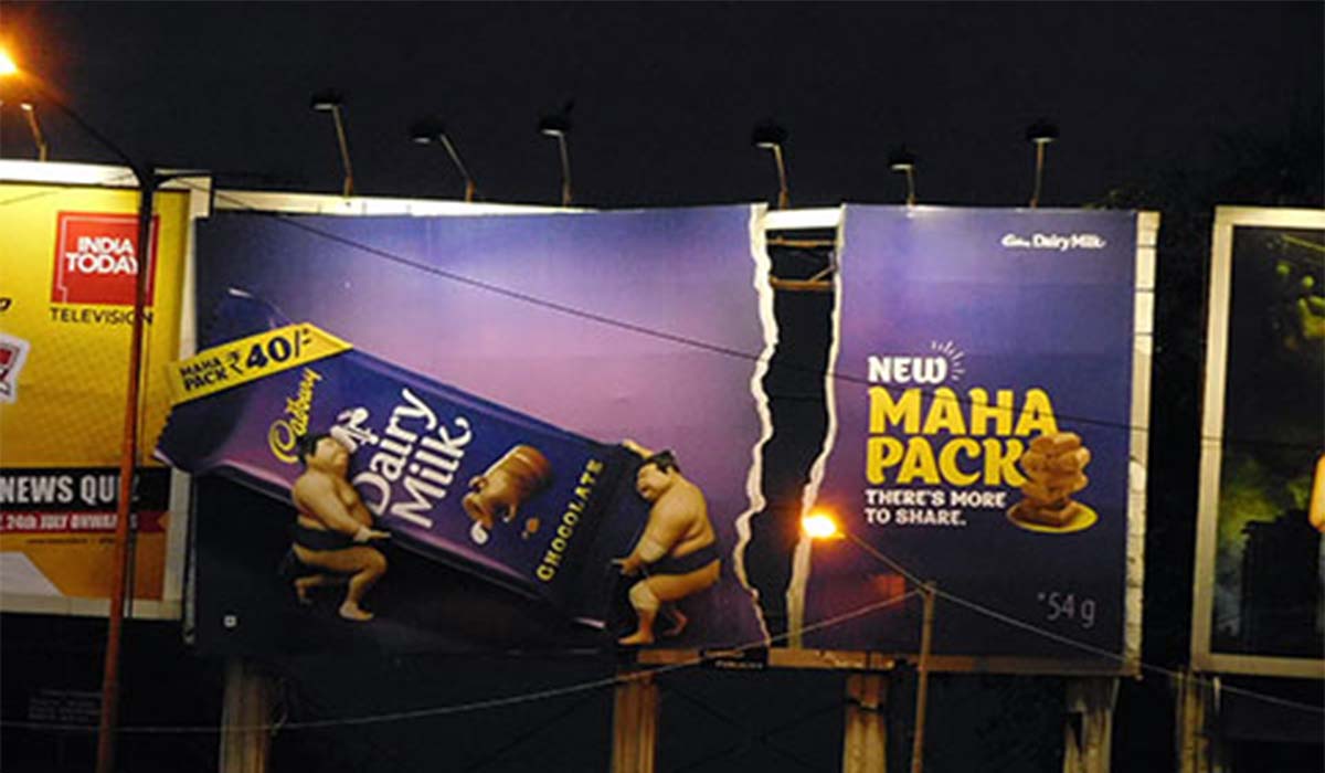 A Cadbury chocolate billboard with a big crack in it.
