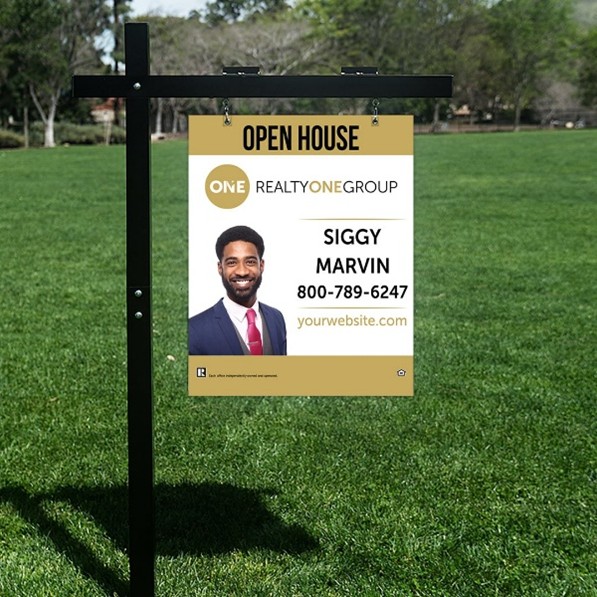 Open house signboard placed on grass with agent photo and contact details