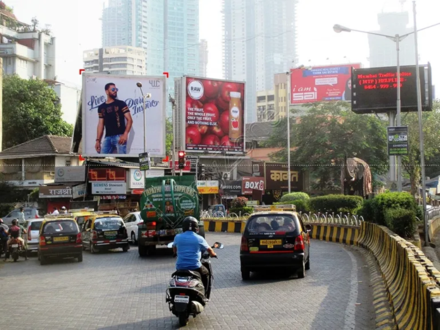 High-traffic Mumbai road junction with multiple large hoardings targeting daily commuters and motorists.