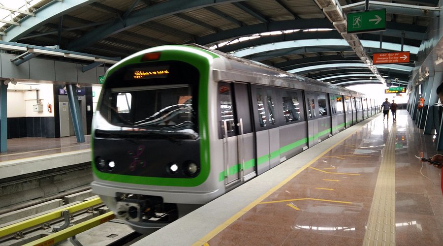 Modern Metro Train at Elevated Station Platform Green and silver metro train halted at an elevated metro station platform.