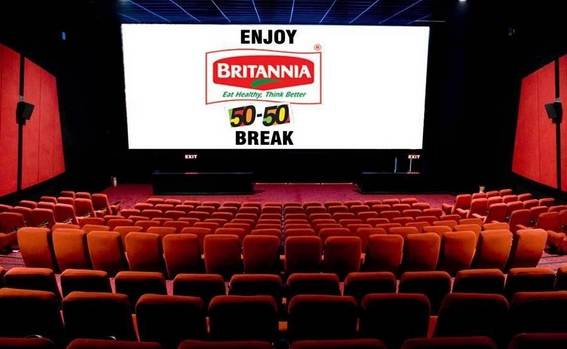Cinema hall screen displaying Britannia 50-50 brand advertisement before a movie
