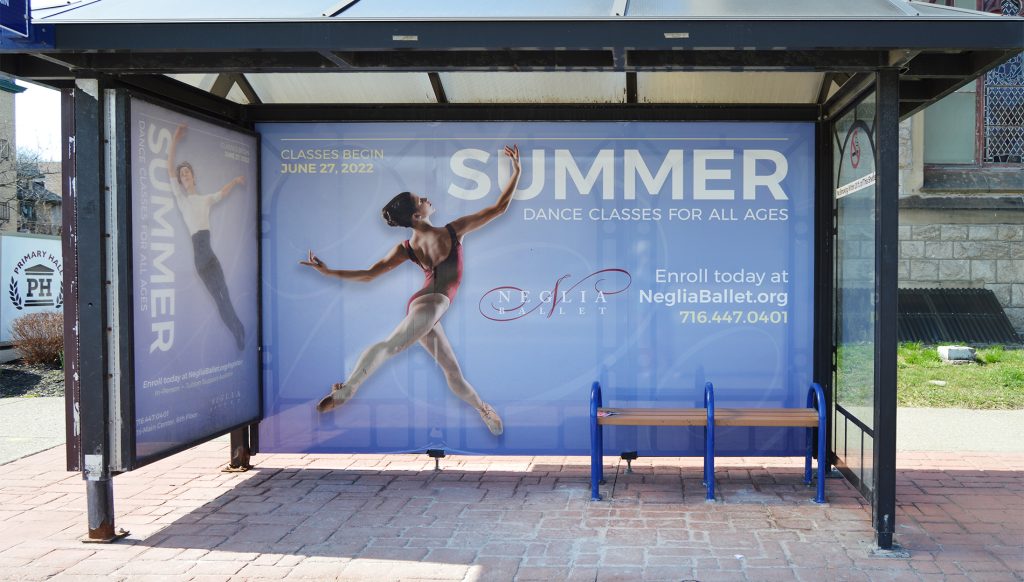 Bus shelter advertisement featuring a ballerina mid-leap promoting summer dance classes for all ages, with enrollment details and website information on a blue background.
