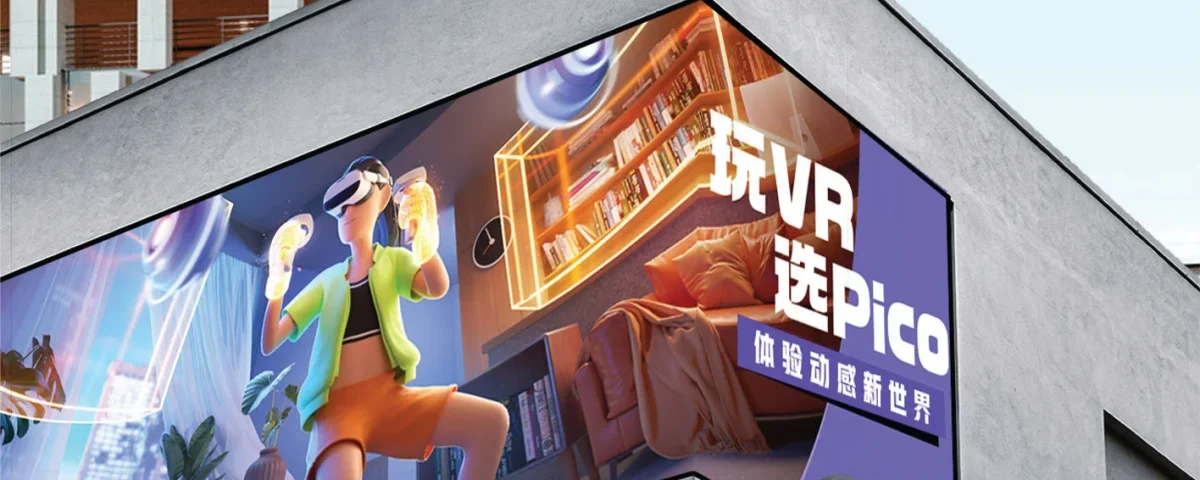 Corner-mounted digital billboard on a modern building displaying an immersive VR gaming advertisement featuring a person using a virtual reality headset.