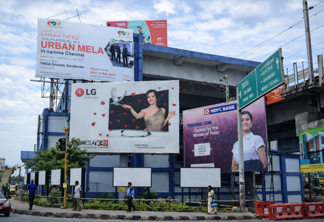 Multiple Billboards At Busy City Junction Street junction with multiple large billboards for electronics, banking and an urban event