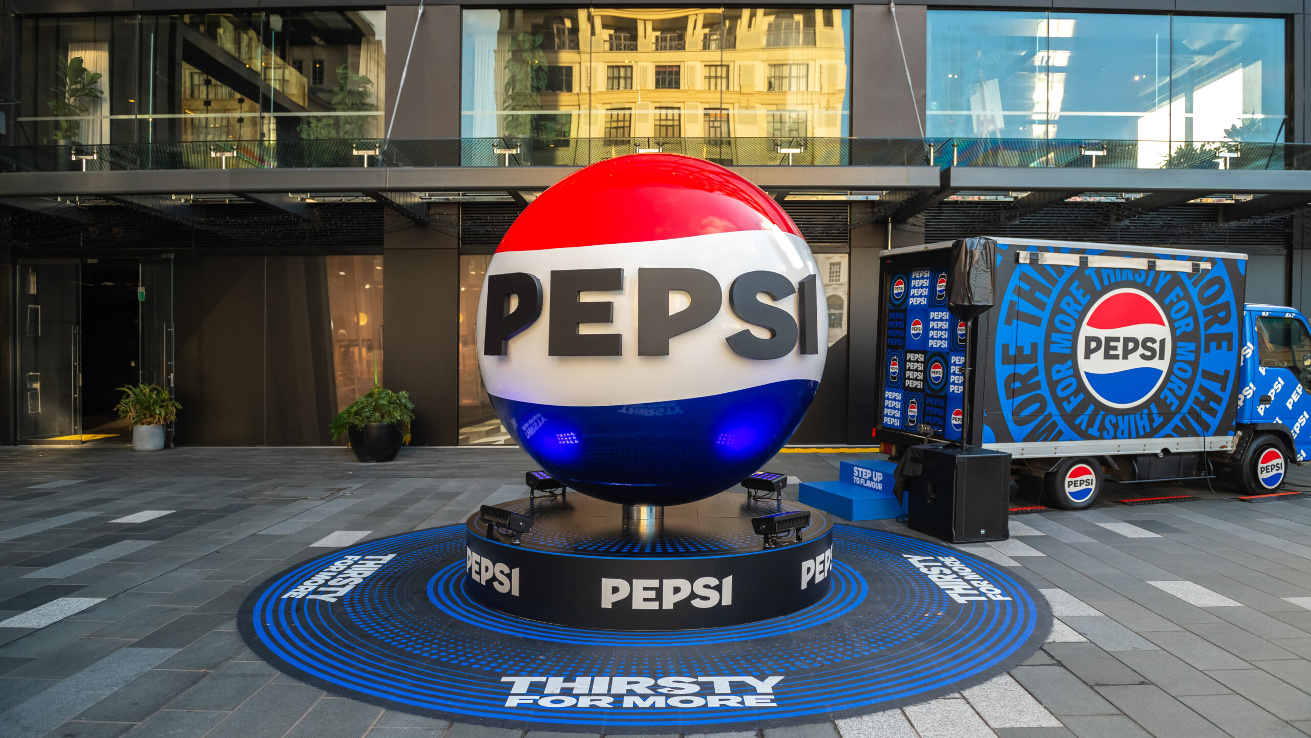 Pepsi 3D Brand Installation and Experiential Activation Large 3D Pepsi sphere installation with branded truck and “Thirsty For More” messaging in a public plaza.