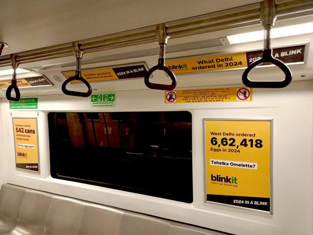 Metro train interior featuring Blinkit advertisements about Delhi order statistics in 2024