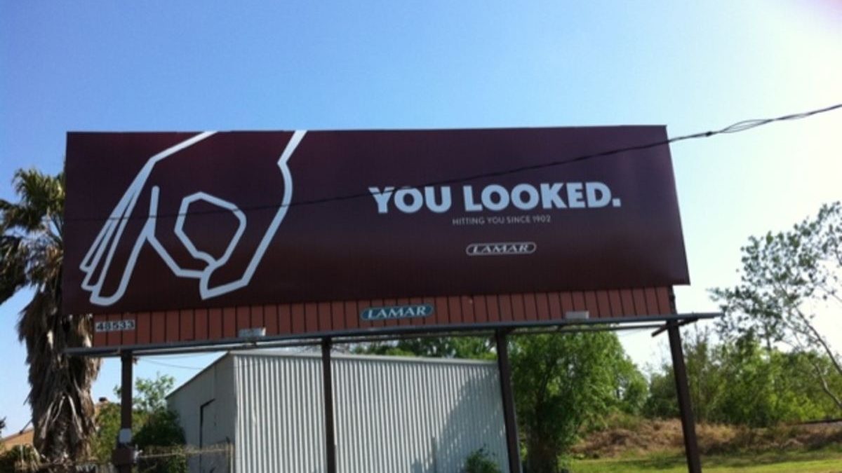 Minimalist billboard reading “You Looked” demonstrating attention-grabbing outdoor advertising