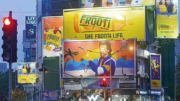Frooti mango drink billboard campaign with vibrant visuals and brand ambassador in busy city street