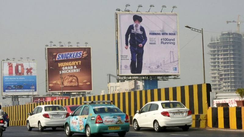 Multiple billboards placed in urban street showcasing diverse outdoor advertising campaigns