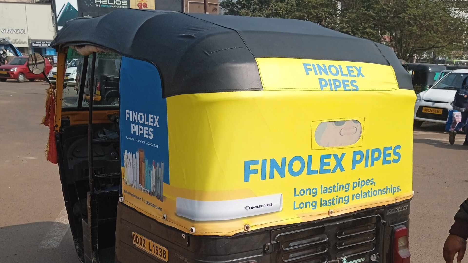 Auto rickshaw wrapped with Finolex Pipes branding promoting long-lasting pipes and relationships on a busy city road.