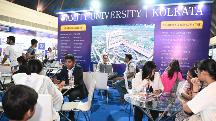 Exhibition booth of Amity University Kolkata at an education fair with students interacting and informational displays.