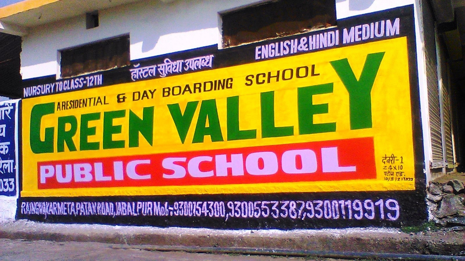 Hand-painted wall advertisement for Green Valley Public School displaying school name, services, and contact details.