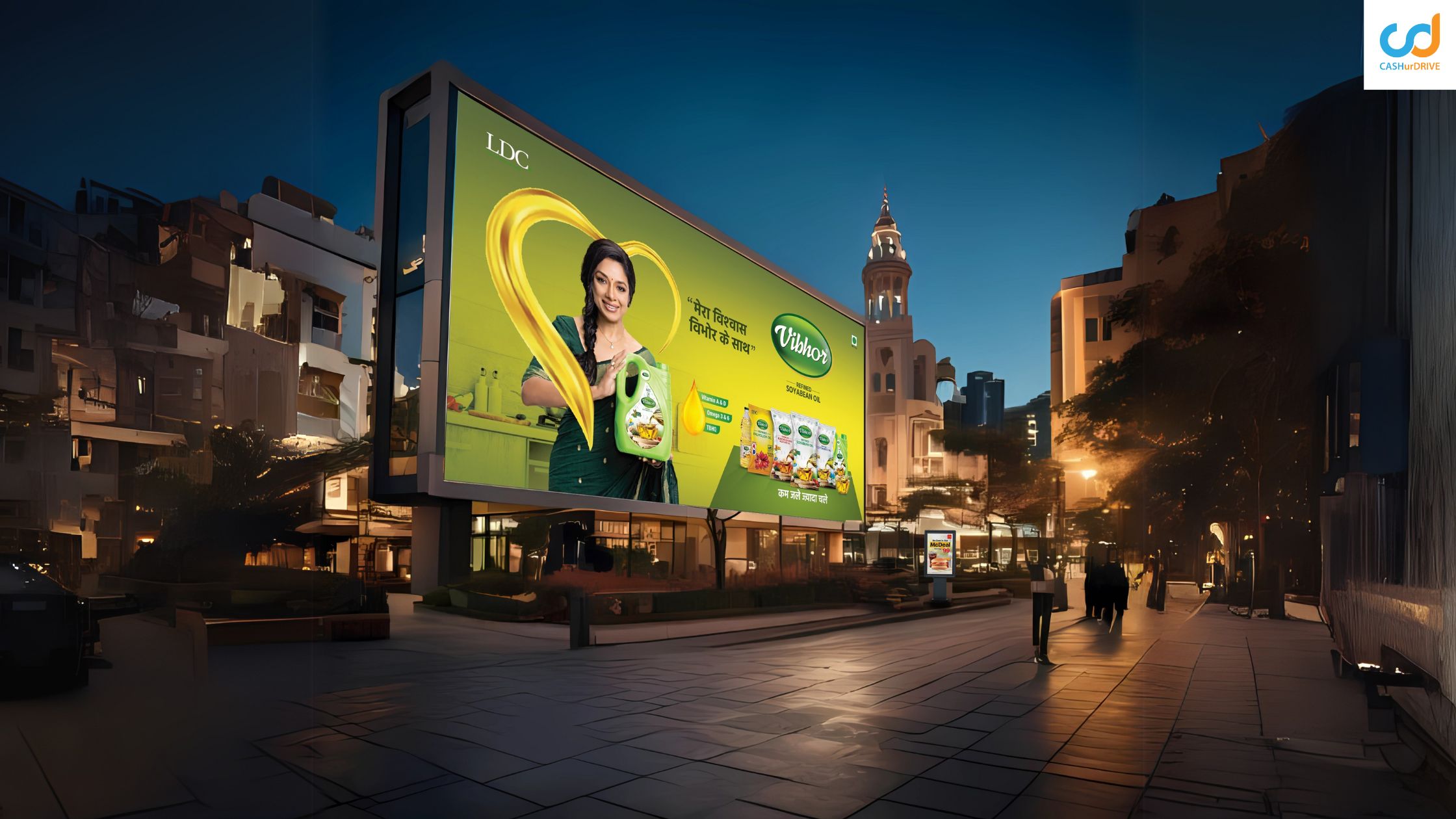 Large outdoor billboard advertising cooking oil brand in a city street at night with illuminated hoarding and high visibility placement