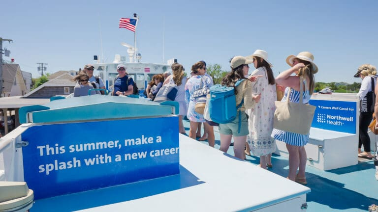 Boat deck advertising by Northwell Health promoting career opportunities with passengers onboard in outdoor setting
