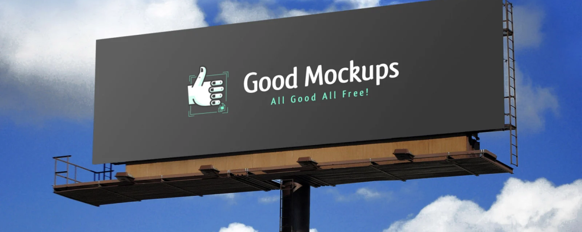 Large outdoor billboard mockup displaying “Good Mockups – All Good All Free!” against a bright blue sky with clouds