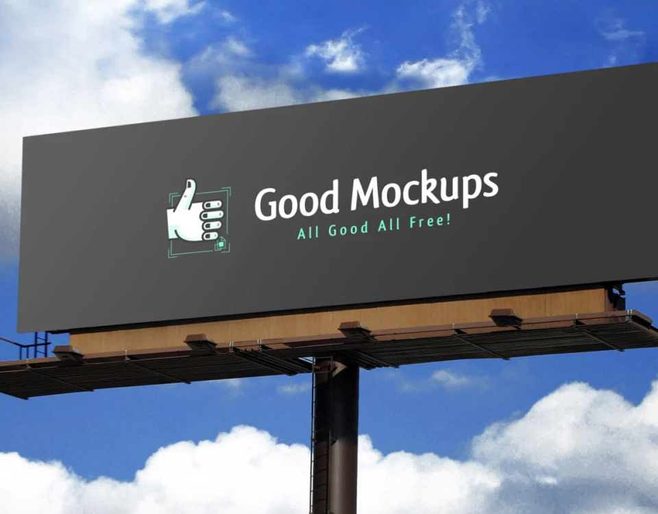 Large outdoor billboard mockup displaying “Good Mockups – All Good All Free!” against a bright blue sky with clouds