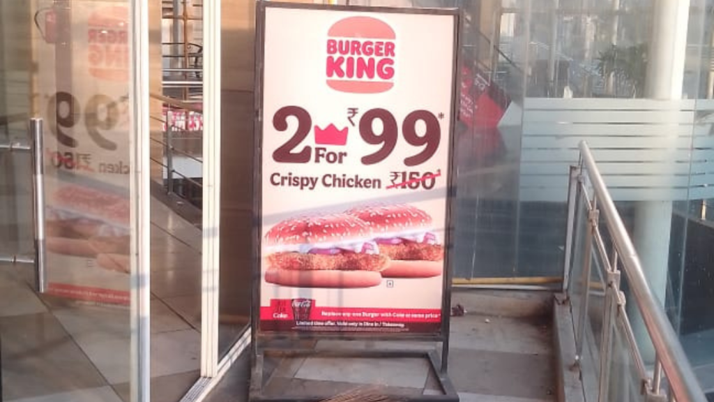 Burger King in-store standee advertising with promotional offer Burger King promotional standee showing offer pricing inside commercial or mall space