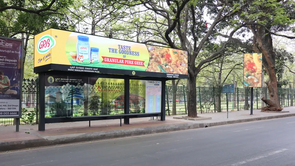 Bus shelter advertising with GRB ghee brand display GRB ghee advertisement on bus shelter with illuminated panel in urban outdoor setting