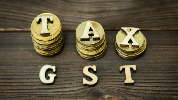 Coins stacked with GST letters representing Goods and Services Tax and financial compliance in India