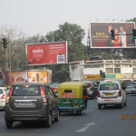 Busy urban road with multiple billboards including Tata 1mg healthcare ad and Netflix Red Notice movie promotion above traffic intersection