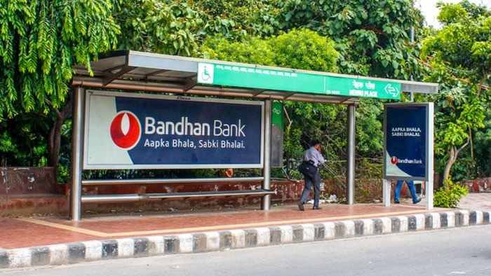 Bandhan Bank bus shelter outdoor advertising campaign Bus shelter advertising by Bandhan Bank with branding panel and pedestrian waiting area on roadside