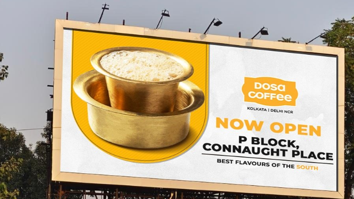 Dosa Coffee outdoor billboard campaign announcing new outlet at Connaught Place Outdoor billboard advertising Dosa Coffee restaurant opening at Connaught Place featuring traditional South Indian filter coffee visual