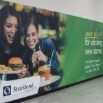Mall wall branding advertising with lifestyle food imagery attracting shoppers in retail environment