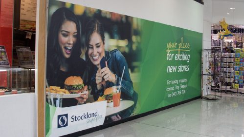 Mall wall branding advertising with lifestyle food imagery attracting shoppers in retail environment